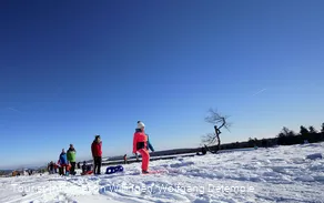 Familie mit Kindern auf Schlitten wandert auf dem Ettelsberg 