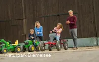 Kinder auf Spielzeugen auf dem Familienbauernhof Fass