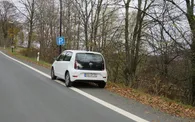 Parkstreifen neben einer Hauptverkehrsstraße mit einem weißen geparkten Auto.