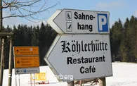 Zwei Wegweiser die zum Parkplatz am Skilift Sahnehang und zur Köhlerhütte führen.