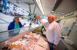 Fischhändler bietet einer Dame Tintenfisch an