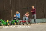 Kinder auf Spielzeugen auf dem Familienbauernhof Fass