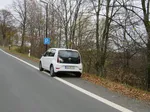 Parkstreifen neben einer Hauptverkehrsstraße mit einem weißen geparkten Auto.