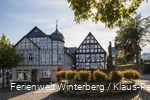 Fachwerkhaus mit dem Kump und der Touristinformation mit einem Brunnen im Vordergrund.