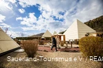 Teil des Galileo-Parks mit den pyramidenförmigen Gebäuden, in denen sich die Ausstellungen befinden. Zwei Freundinnen laufen durch den Park.